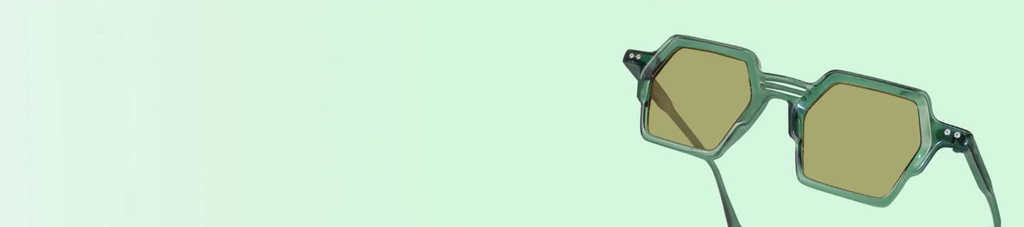 A close-up of premium black-framed pilots with polarised lenses, displayed on a geometric white block against a soft, bright background.