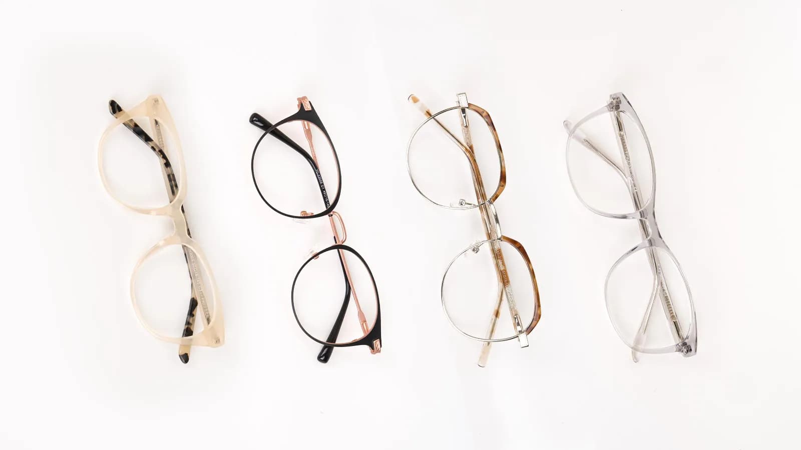 Four different pairs of glasses, including clear, black, gold metal, and grey acetate frames, arranged vertically against a plain white background.
