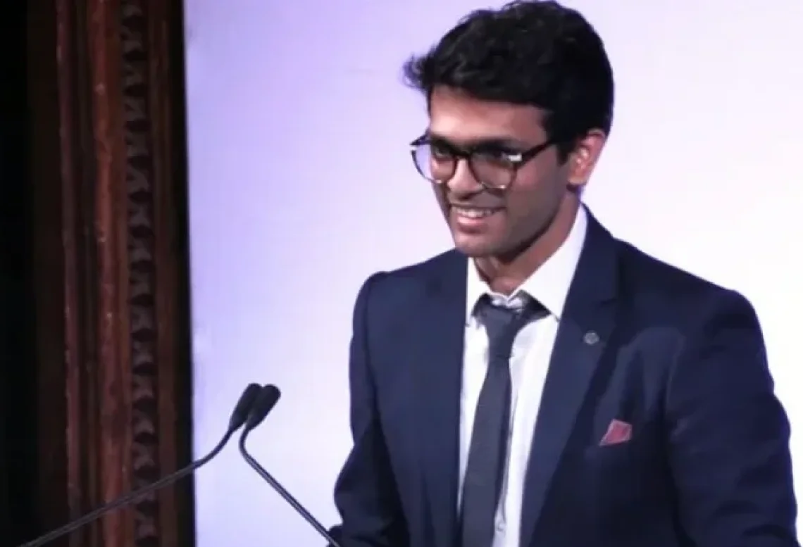 Sid Sethi, Specscart’s founder, speaking at a podium in formal attire during the Venture Further Awards event. The background includes event branding, emphasising his role on the judging panel in 2023.