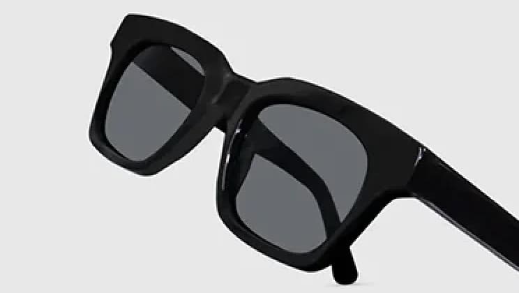 High-quality rectangular sunglasses featuring glossy black acetate frames and dark-tinted lenses, displayed against a light grey background to highlight durability and premium materials.