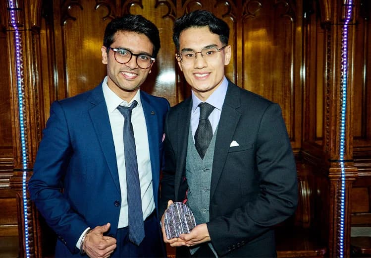 Sid Sethi, Specscart’s founder, and another man in a formal suit, posing together in front of ornate wood panelling. The second man holds an event trophy, reflecting a celebratory moment at the Venture Further Awards 2023.