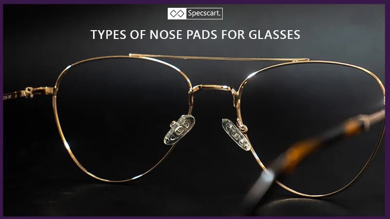 Types of Nose Pads for Glasses A close-up of a pair of gold-framed pilot glasses highlights the clear, oval-shaped nose pads resting on the bridge. The image is set against a dark background.