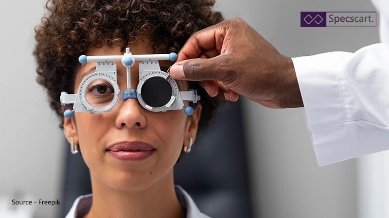 How Much Can I Claim From My Employer for Glasses? A woman having an eye examination using a phoropter to determine her correct prescription, symbolising the need for workplace eye tests and glasses funding.