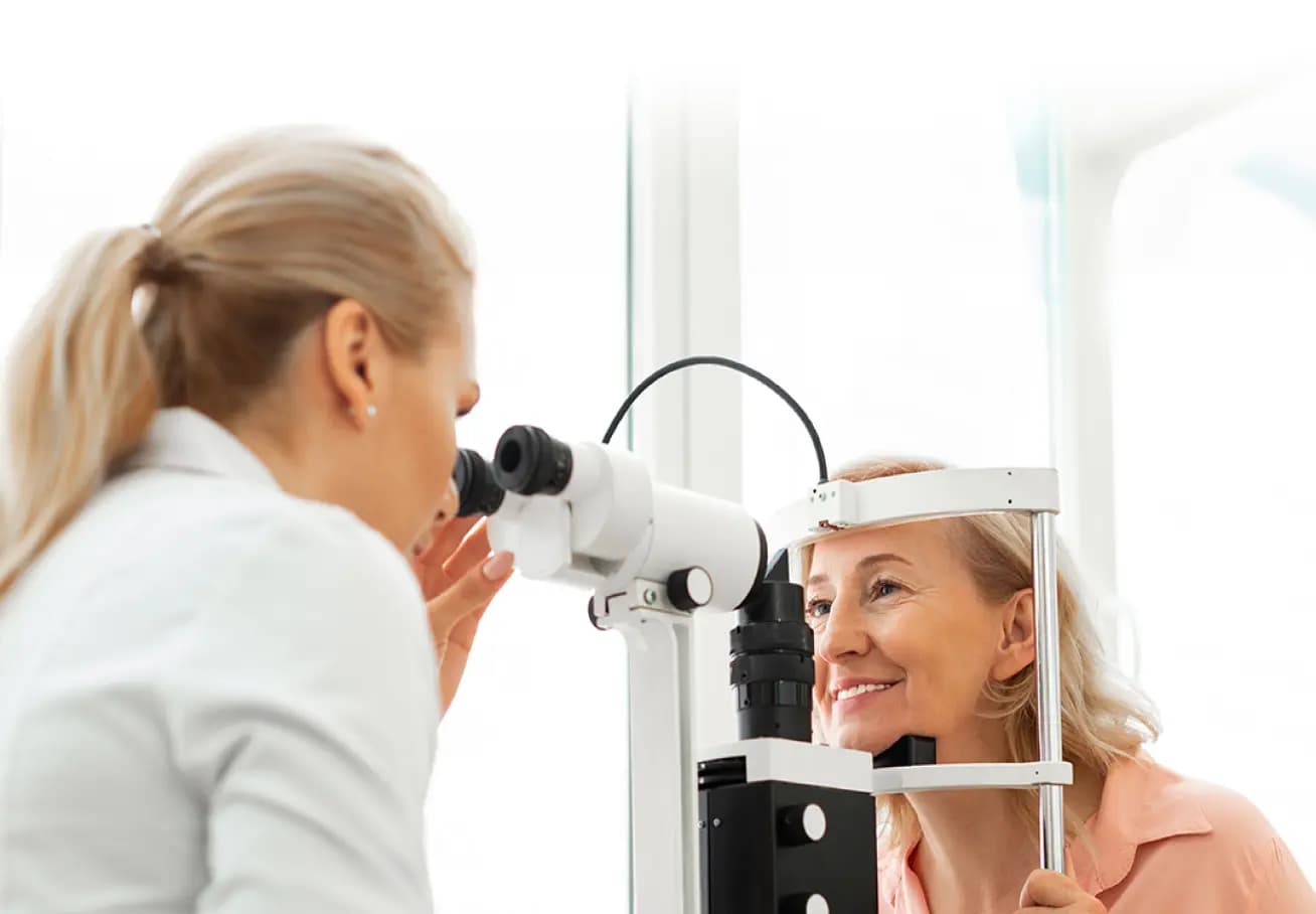 Free Eye Test: An optometrist conducting an eye examination on a female patient using a slit lamp, symbolising a professional eye test service.