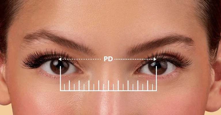 Image showing a person's eyes with a dashed line connecting the centre of their pupils labeled 'PD', and a ruler graphic below, demonstrating the process of measuring pupillary distance for glasses.