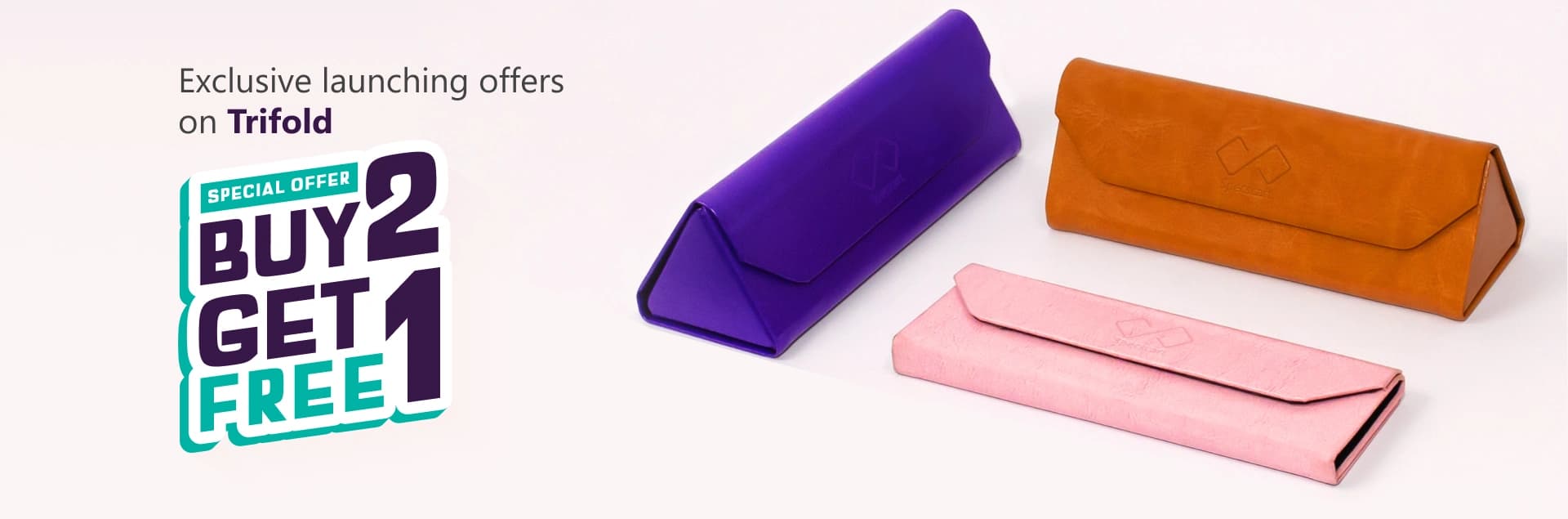 Banner advertising ‘Exclusive Launching Offer On Trifold, Buy 2 Get 1 Free’ featuring three pastel-coloured Specscart trifold cases in pink, purple, and brown, arranged in pairs on a pale background.