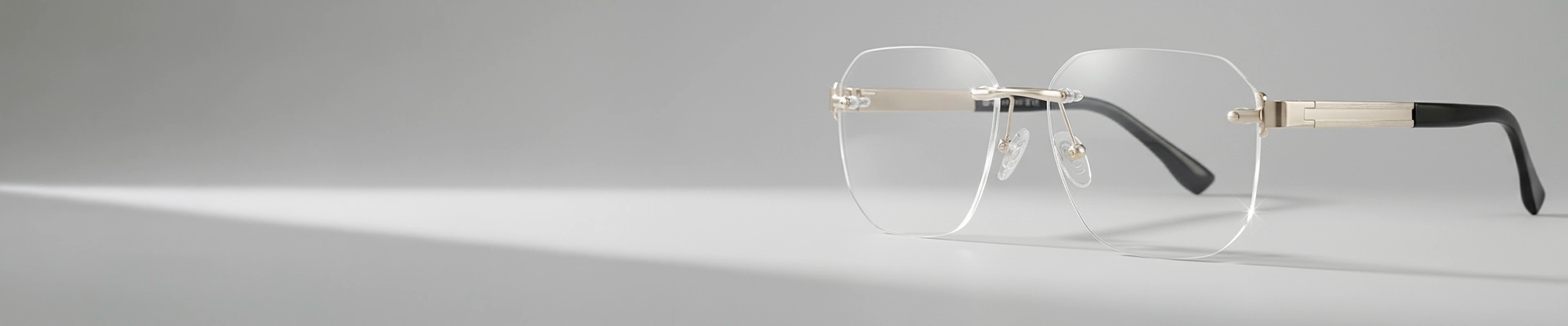 Rimless Glasses Minimalist rimless eyeglasses with rectangular lenses, silver bridge and temples, and black temple tips, shown on a light grey background