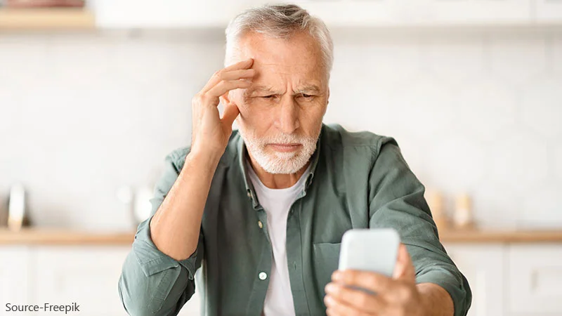 Image
of an elderly man finding it difficult to see his phone
