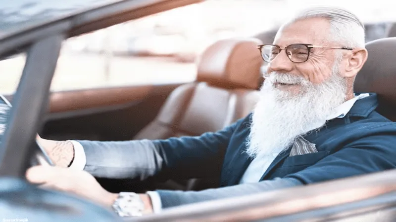 Image of an
      elderly man wearing glasses and driving